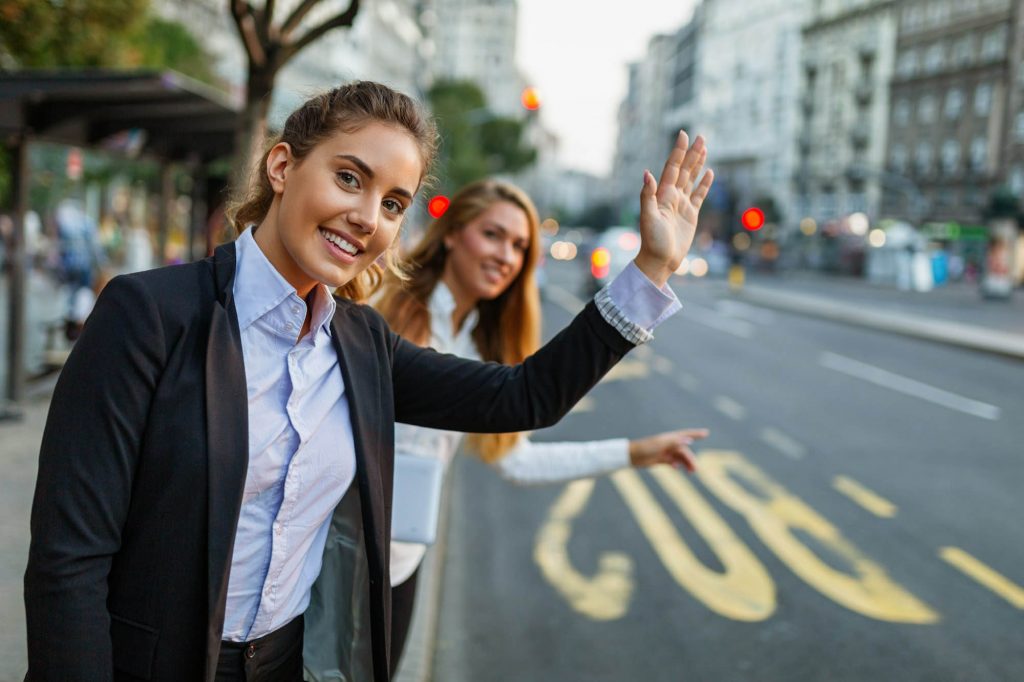 Young smiling business woman catching taxi at city street woman looking for a taxi.jpg